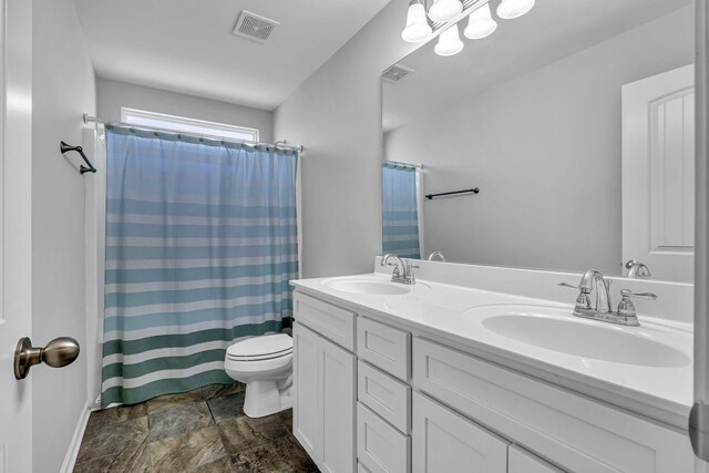 bathroom with curtained shower, vanity, and toilet