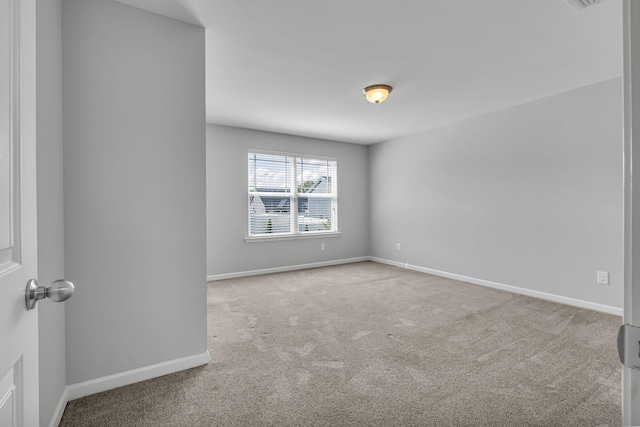 unfurnished room featuring light colored carpet