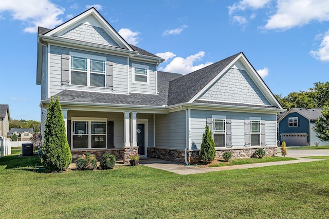 craftsman house with central air condition unit and a front lawn