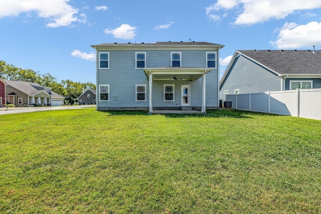 back of property featuring a lawn, a patio area, and ceiling fan