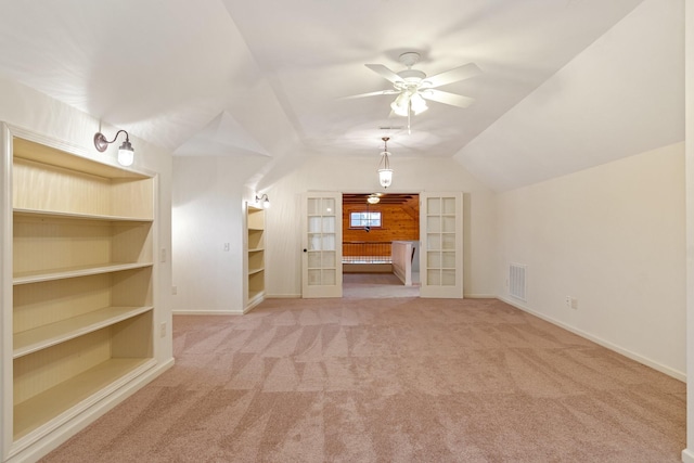 additional living space with carpet, lofted ceiling, french doors, ceiling fan, and built in shelves