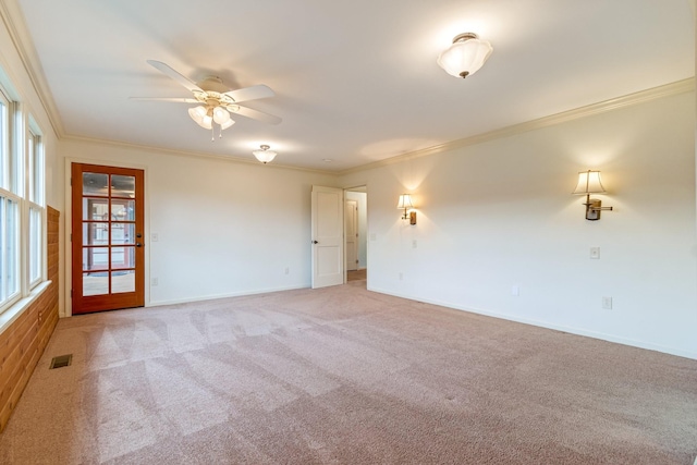 carpeted spare room featuring ceiling fan and crown molding