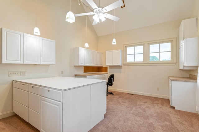 kitchen with ceiling fan, white cabinets, light colored carpet, and high vaulted ceiling