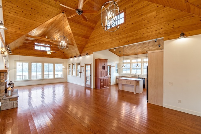 unfurnished living room with a healthy amount of sunlight, high vaulted ceiling, wooden ceiling, and ceiling fan with notable chandelier