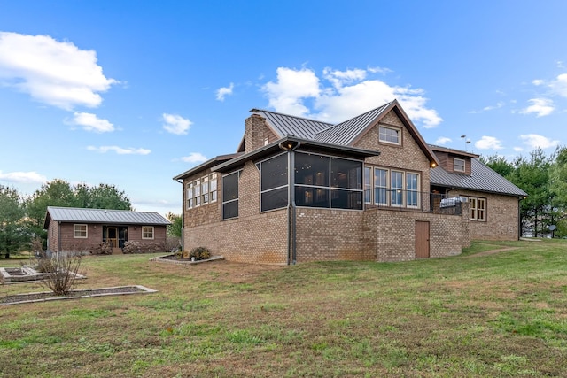 rear view of property with a sunroom and a yard