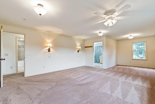 empty room with ceiling fan, light colored carpet, and ornamental molding