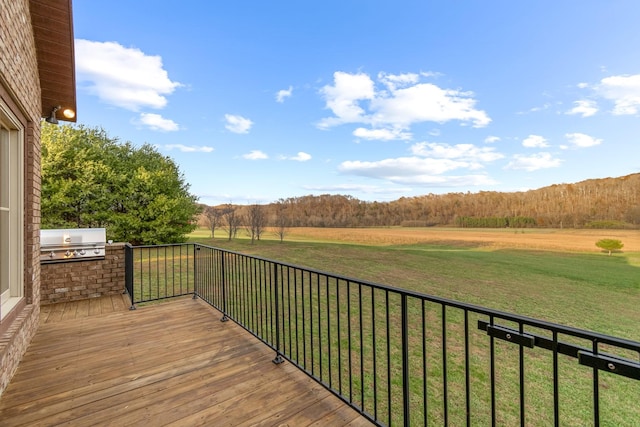 deck featuring area for grilling, a rural view, and a yard