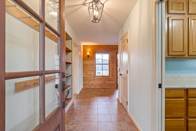 corridor with tile patterned floors and wooden walls