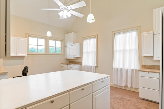 kitchen with white cabinetry, hanging light fixtures, lofted ceiling, and ceiling fan