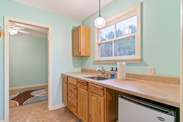 kitchen with ceiling fan, sink, hanging light fixtures, and stainless steel dishwasher