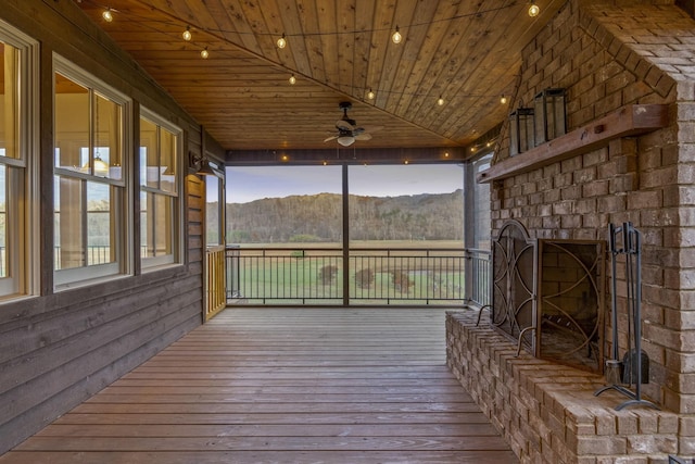 wooden deck with a mountain view and ceiling fan