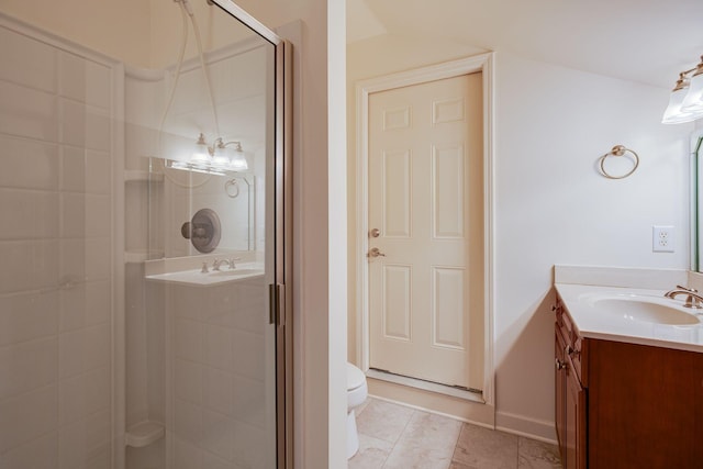 bathroom featuring tile patterned floors, vanity, toilet, and a shower with shower door