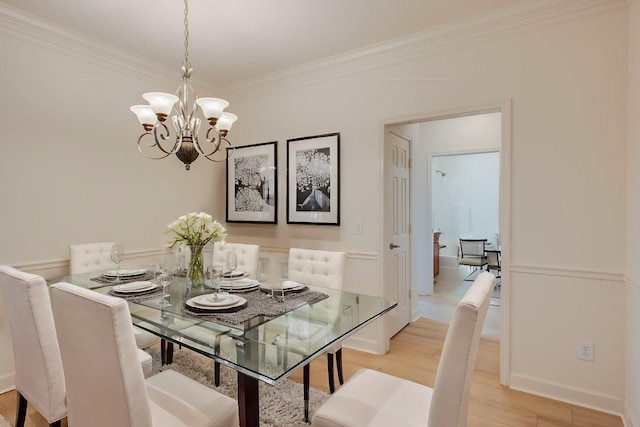 dining room featuring light hardwood / wood-style flooring, ornamental molding, and a notable chandelier