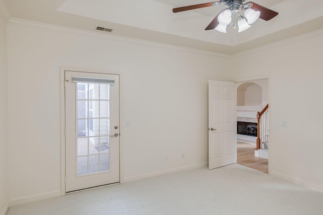 carpeted spare room featuring ceiling fan and crown molding