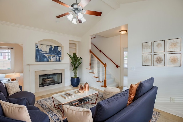 living room with hardwood / wood-style floors, lofted ceiling with beams, ceiling fan, and built in shelves