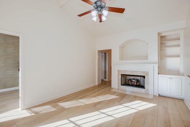 unfurnished living room featuring ceiling fan, built in features, and light hardwood / wood-style flooring