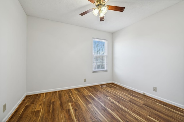 empty room with dark hardwood / wood-style floors and ceiling fan