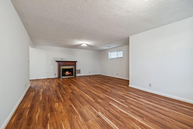 unfurnished living room featuring dark hardwood / wood-style floors and a textured ceiling