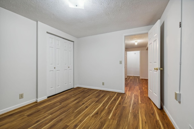 unfurnished bedroom featuring dark hardwood / wood-style flooring, a closet, and a textured ceiling