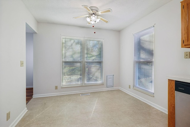 unfurnished dining area with a textured ceiling and ceiling fan