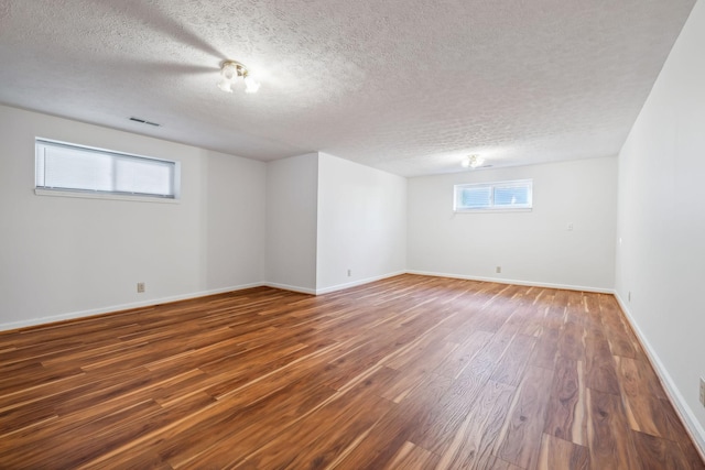 basement featuring hardwood / wood-style floors and a textured ceiling