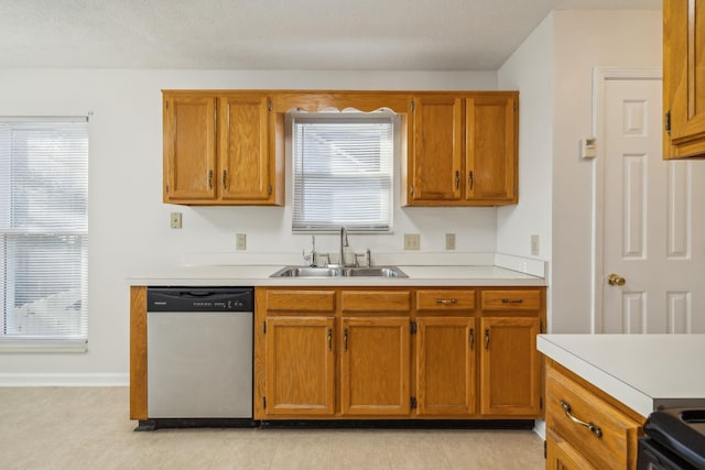 kitchen with sink, light tile patterned floors, range, a textured ceiling, and stainless steel dishwasher