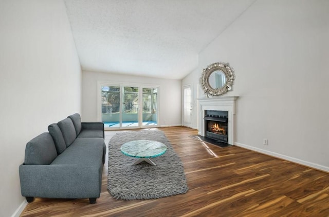 living room with lofted ceiling, dark hardwood / wood-style floors, and a textured ceiling