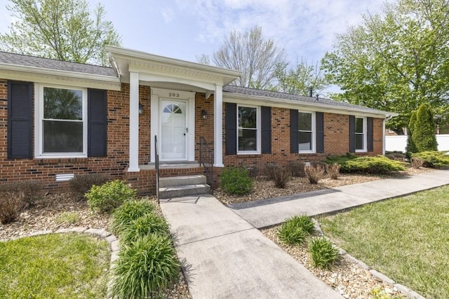 single story home featuring brick siding