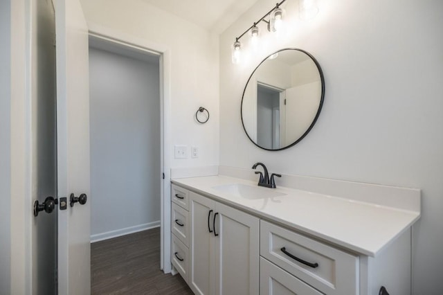 bathroom featuring vanity, baseboards, and wood finished floors