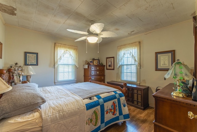 bedroom with multiple windows, dark hardwood / wood-style floors, ceiling fan, and ornamental molding