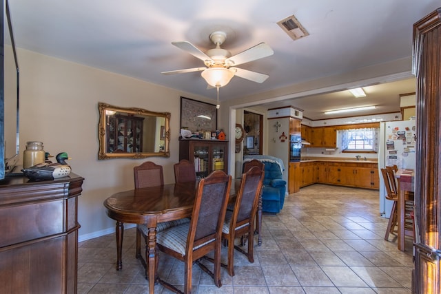 dining space featuring light tile patterned floors, ceiling fan, and sink