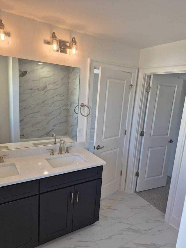 full bathroom featuring marble finish floor, a sink, and a tile shower