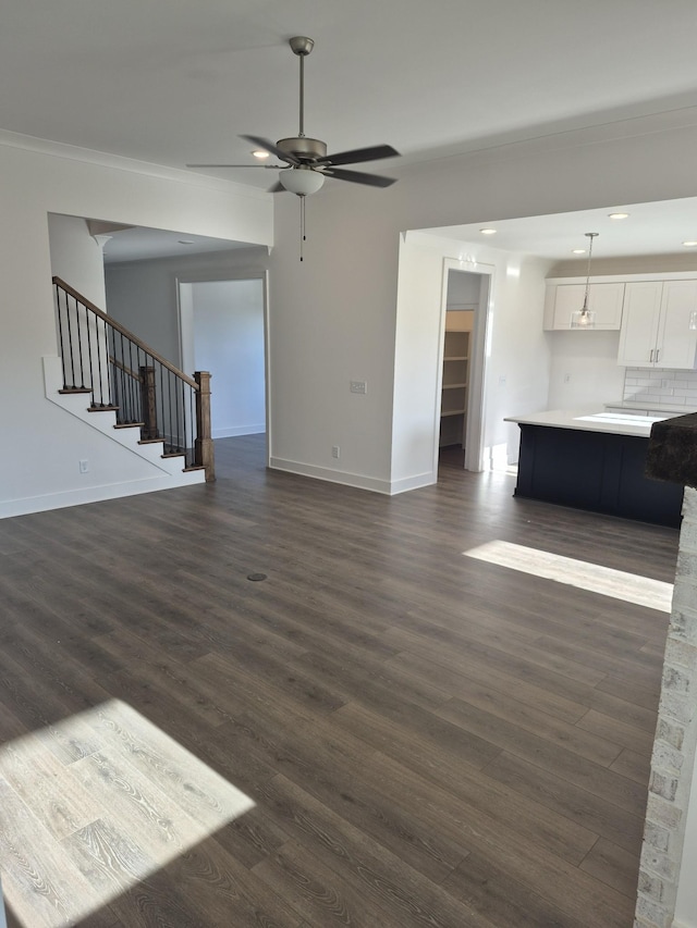 unfurnished living room featuring dark hardwood / wood-style flooring and ceiling fan