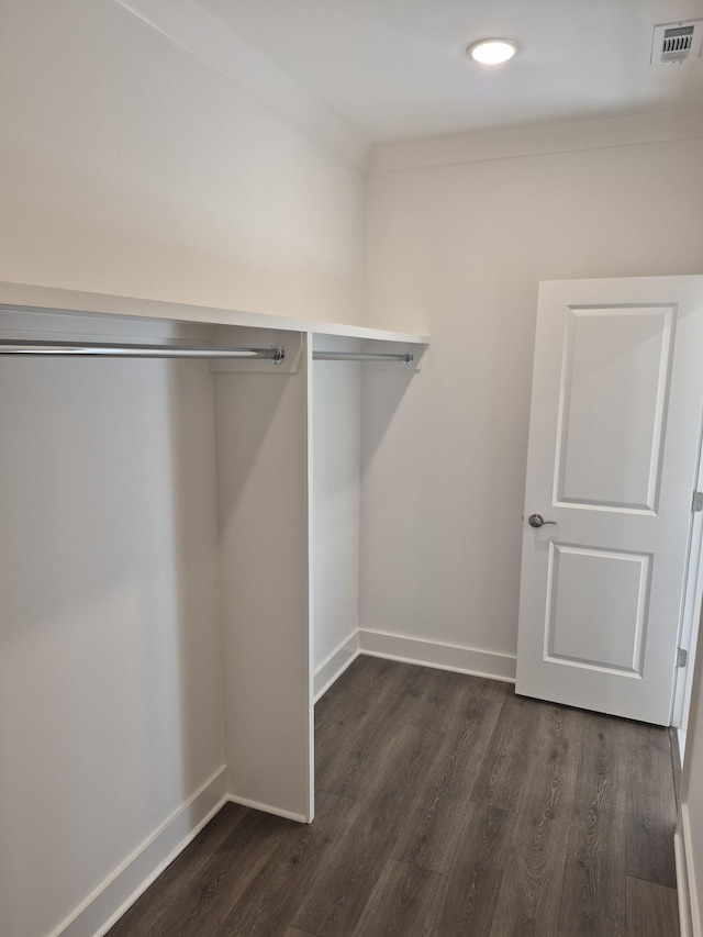 spacious closet with dark wood-style flooring and visible vents