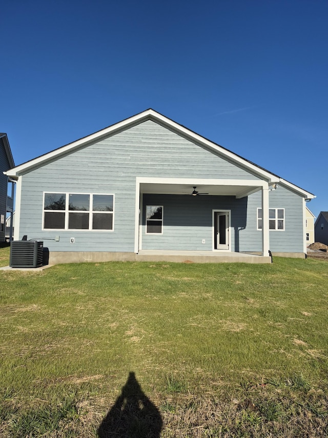 back of house featuring a ceiling fan, a yard, and central AC unit