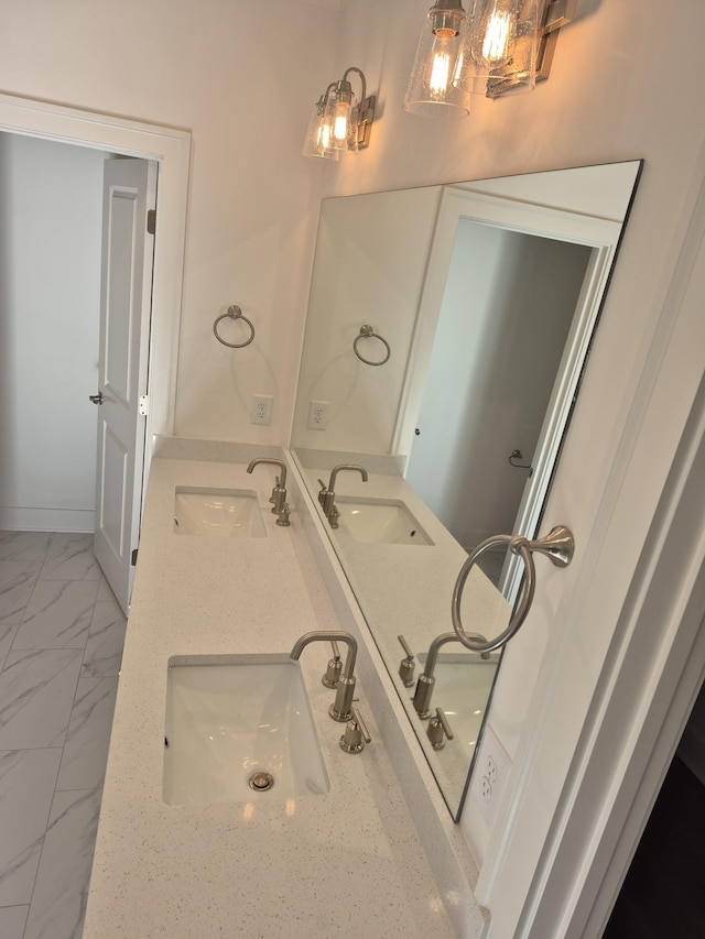 bathroom with double vanity, marble finish floor, and a sink