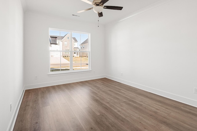 unfurnished room featuring dark wood-style flooring, visible vents, and baseboards