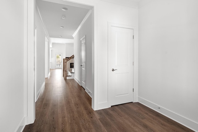 hallway with dark wood-style floors, crown molding, stairs, and baseboards