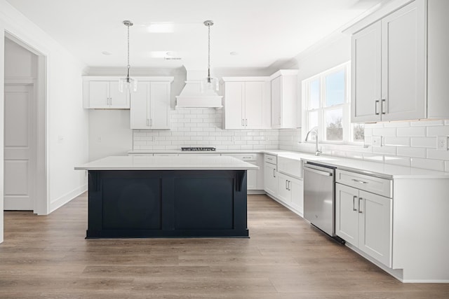 kitchen featuring premium range hood, stainless steel dishwasher, light wood-style flooring, and white cabinetry