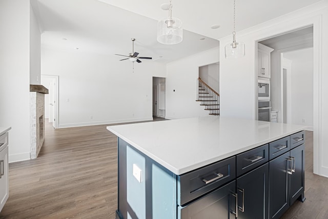 kitchen with light wood-style floors, built in microwave, light countertops, and stainless steel oven