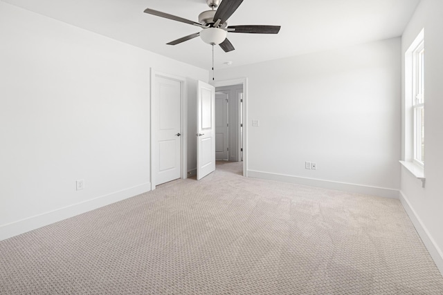 unfurnished bedroom featuring light colored carpet, ceiling fan, and baseboards