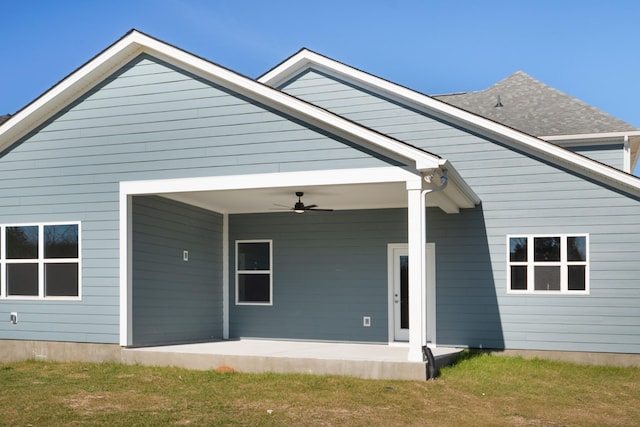 back of property with ceiling fan, a patio, and a yard