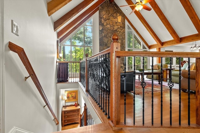 stairway with beam ceiling, hardwood / wood-style flooring, high vaulted ceiling, and ceiling fan