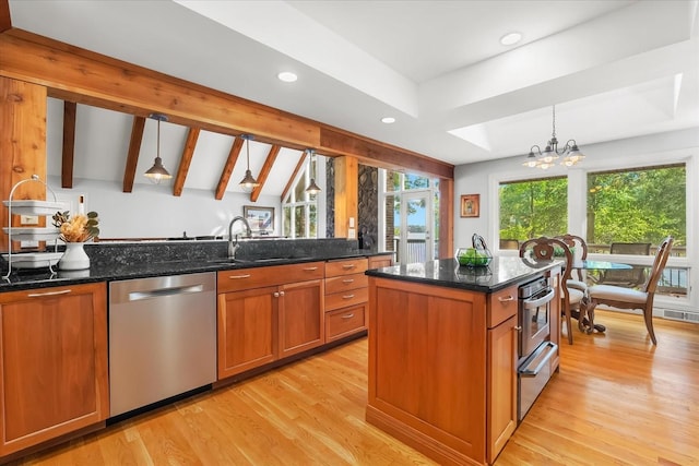 kitchen with appliances with stainless steel finishes, dark stone countertops, pendant lighting, and a notable chandelier