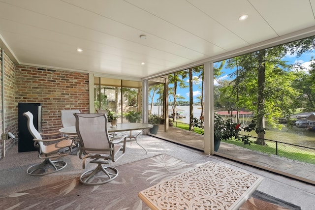 sunroom / solarium with a wealth of natural light and a water view