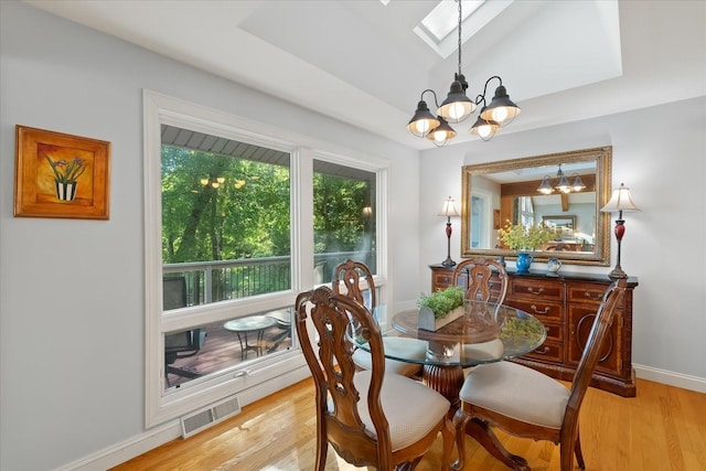 dining room featuring light wood-type flooring and an inviting chandelier