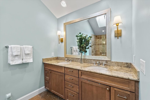 bathroom featuring tile patterned floors, vanity, and lofted ceiling with skylight