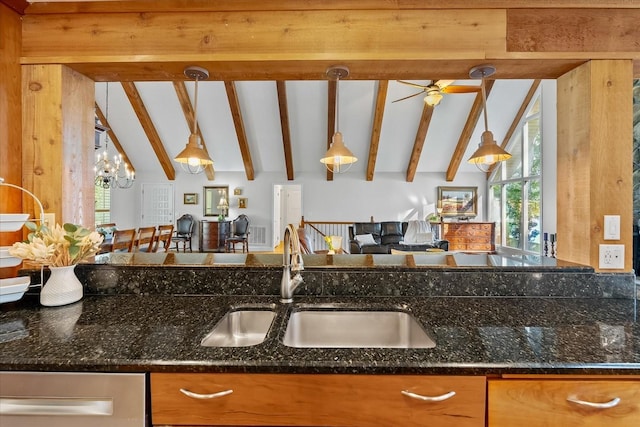 kitchen featuring sink, dark stone counters, and decorative light fixtures