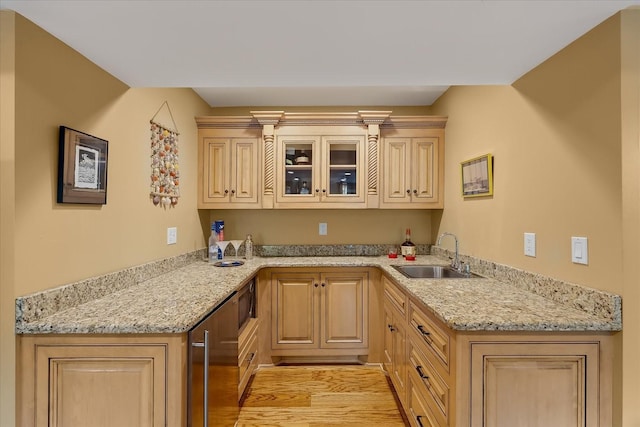 kitchen with light brown cabinetry, light hardwood / wood-style flooring, and sink