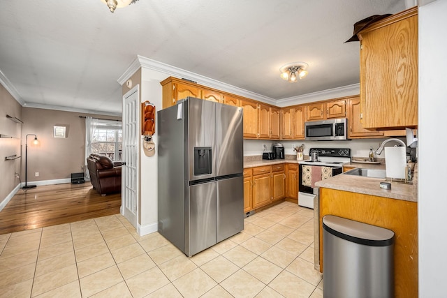 kitchen featuring light hardwood / wood-style floors, sink, ornamental molding, and appliances with stainless steel finishes